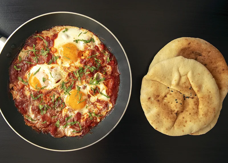 Shakshuka — eieren gepocheerd in een tomaten-paprikasaus met feta