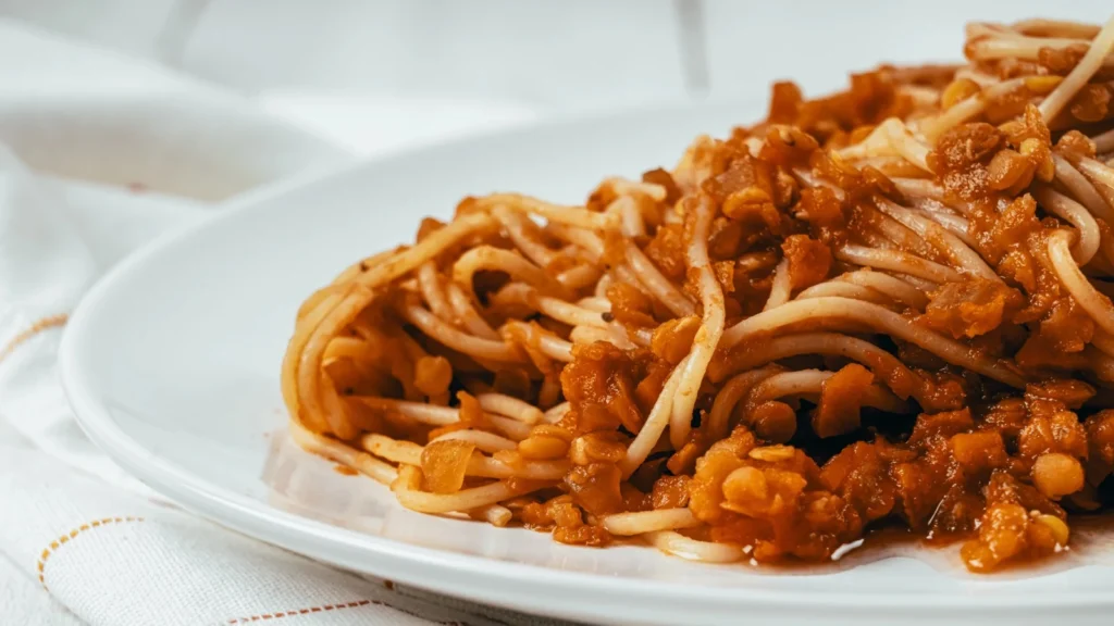 Linzen-bolognese met rode linzen op brede pasta