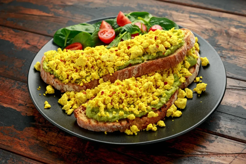 Tofu-scramble als plantaardig roerei met kurkuma in een koekenpan